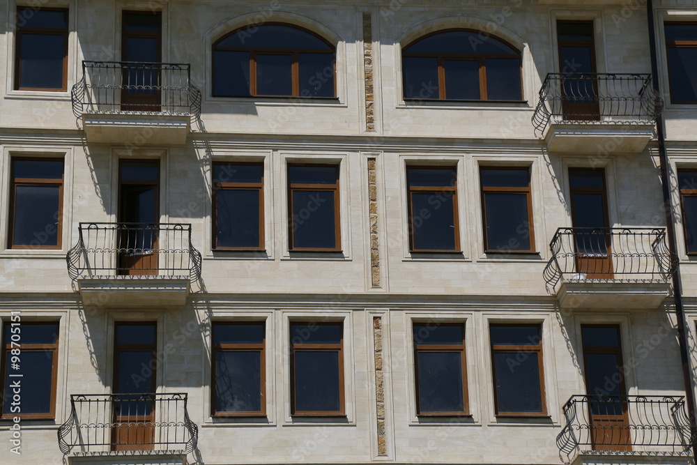 Windows and balconies of modern building in retro style.