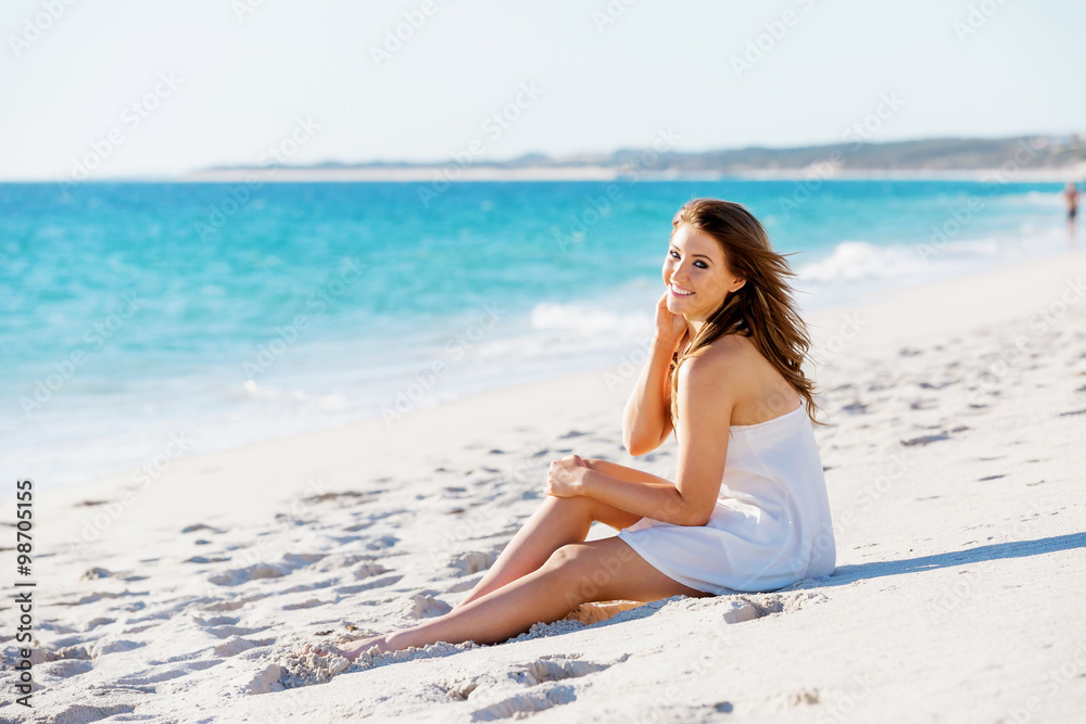 Young woman sitting on the beach Young woman sitting on the beach