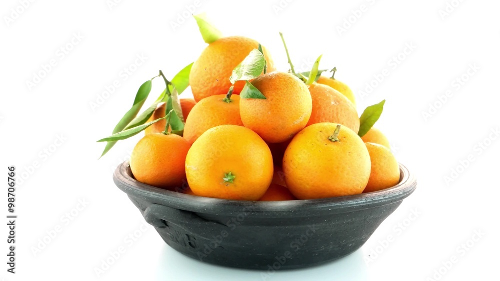 Tangerines on clay bowl isolated on white background Tangerines on clay bowl isolated on white background