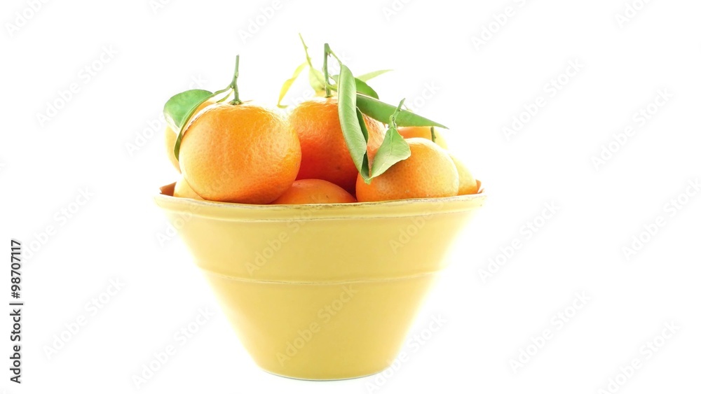 Tangerines on ceramic yellow bowl isolated on white background Tangerines on ceramic yellow bowl isolated on white background