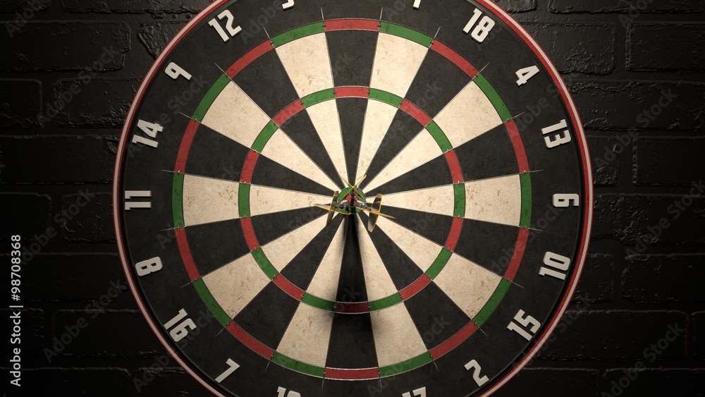 Darts arrow hitting in the bullseye of the dartboard hanging on the dark wall. Darts arrow hitting in the bullseye of the dartboard hanging on the dark wall.
