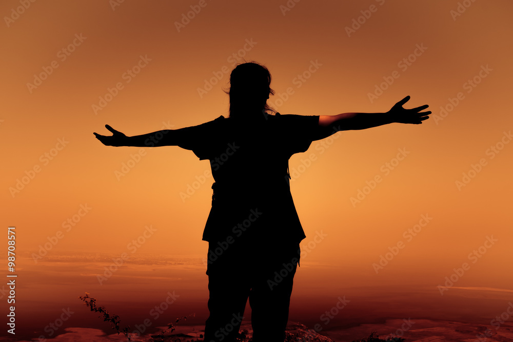 Silhouette back view of woman open arms under the sunrise. Silhouette back view of woman open arms under the sunrise.