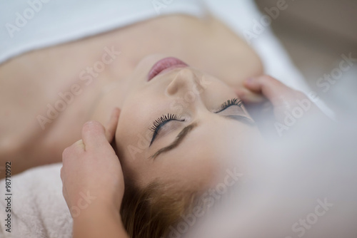 woman getting face and head  massage in spa salon