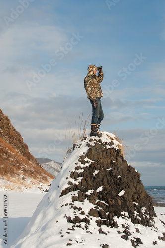 Observation/Photo of a tourist standing on the cliff, watching the horizon