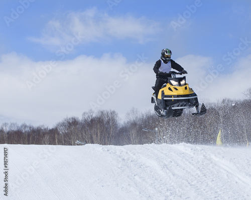Snowmobile on the route in a jump in air