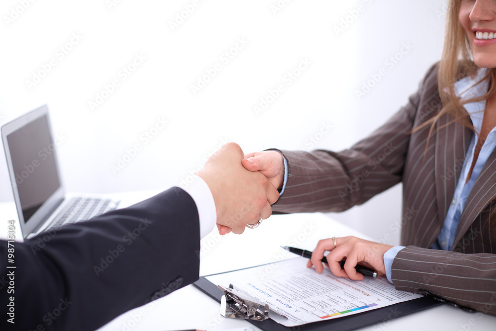 Obraz premium business handshak sitting at the desk on office background, copy space area at the left upper corner