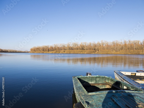 Old boat on the shore of the autumn river 