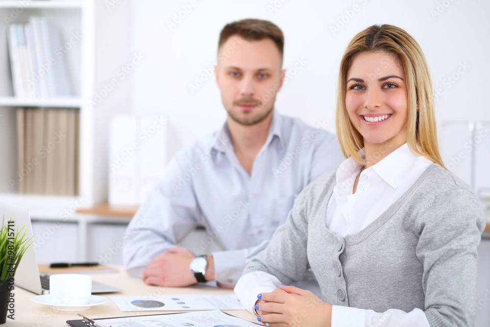 Successful businesspeople working at meeting in office. Business woman looking at camera. Start up business concept. Successful businesspeople working at meeting in office. Business woman looking at camera. Start up business concept.