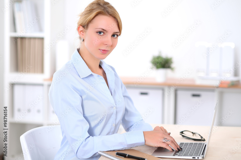 Young blonde business woman with laptop in the office. Business concept. Young blonde business woman with laptop in the office. Business concept.