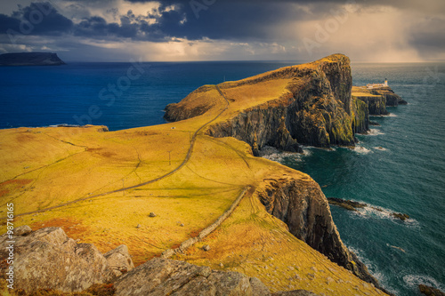 Obraz na płótnie Dramatic cloudy and rainy sky over Neist Point and its lighthouse on Isle of Skye, Scotland, UK w salonie