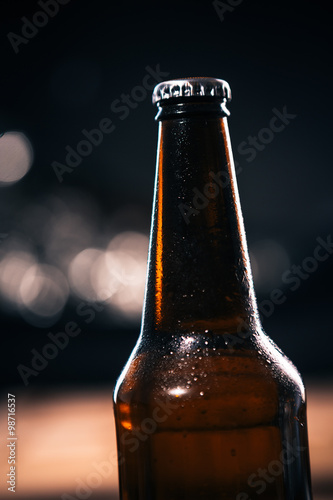 dark bottle of dark beer on a  blurred background