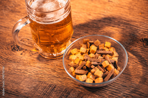 Fototapeta Naklejka Na Ścianę i Meble -   glass of fresh bright beer and crackers on wooden table