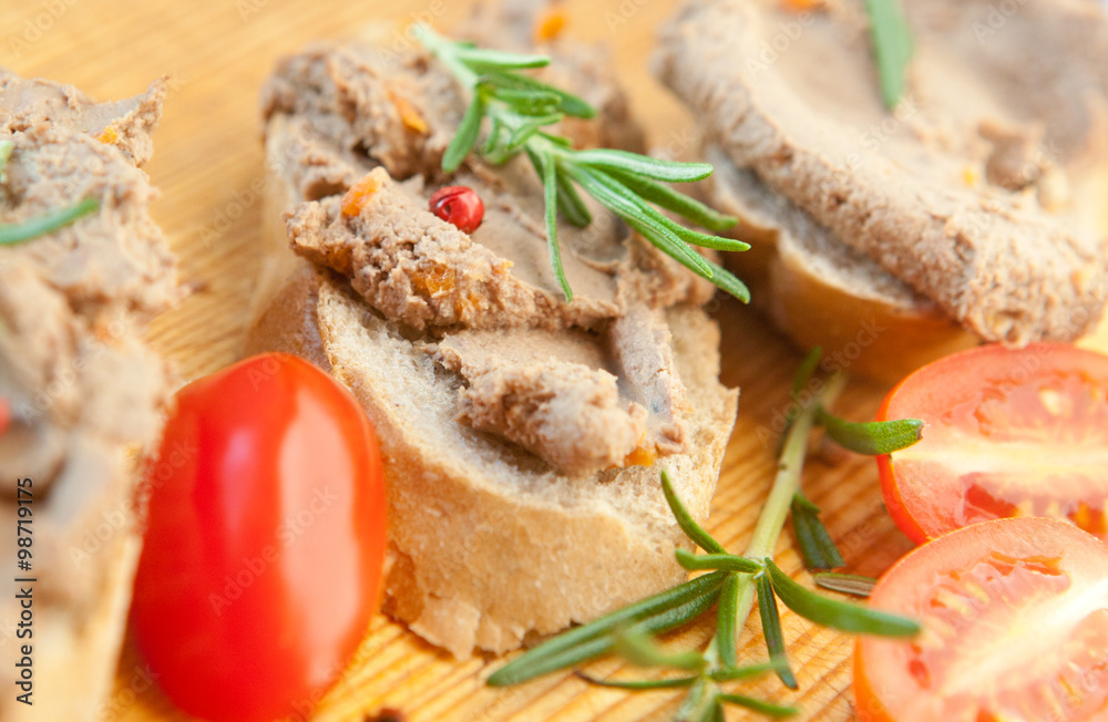 Chicken liver pate on bread with cherry tomatoes and a sprig of rosemary