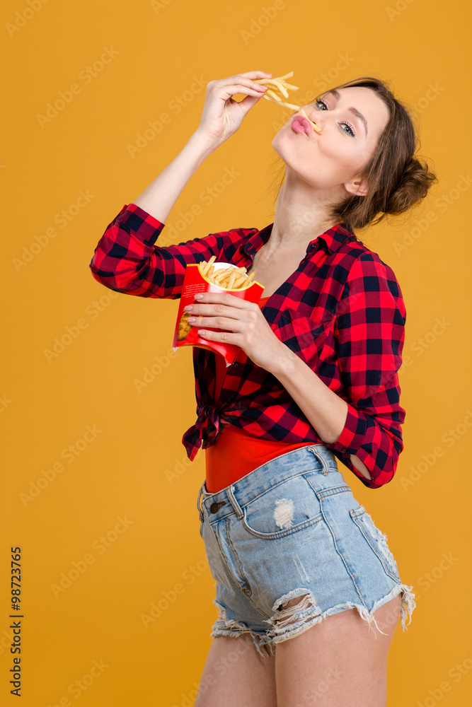 Amusing comical cute young woman having fun with french fries Amusing comical cute young woman having fun with french fries
