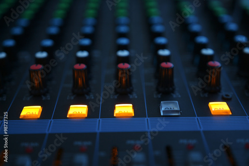 Close up of the rows of knobs and sliders on an analogue mixing