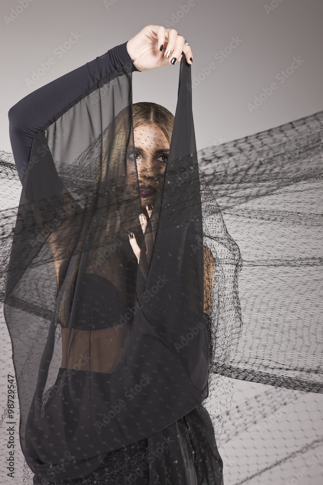 Naklejka premium Model hiding behind a black fabric