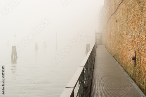 walking in Venice in a foggy day, no people around photo