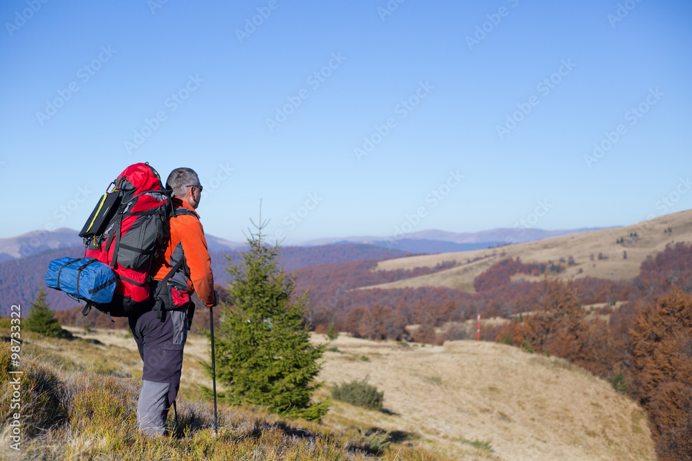 Hikers with backpacks enjoying valley view from top of a mountain