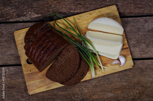 slised loaf of rye bread with cheese and spring onion closeup photo