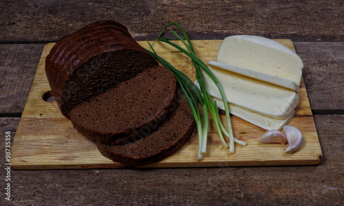 Φωτογραφία slised loaf of rye bread with cheese and spring onion closeup