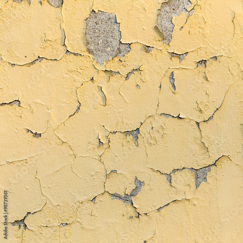 peeling yellow and white paint on a rough surface