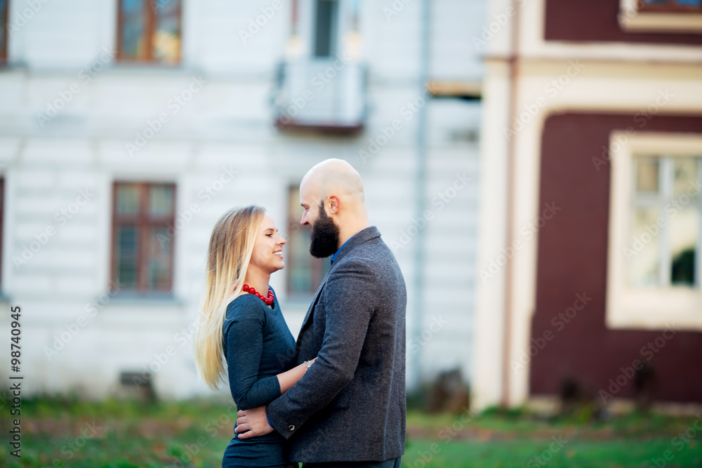 Fototapeta premium Portrait of happy couple hugging in the city and standing face to face. Beautiful people in love.