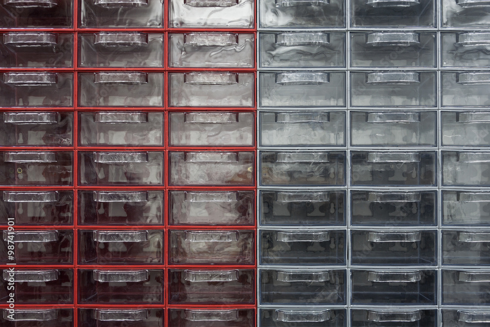 Small plastic transparent, empty drawers in red and gray carriers. Small plastic transparent, empty drawers in red and gray carriers.