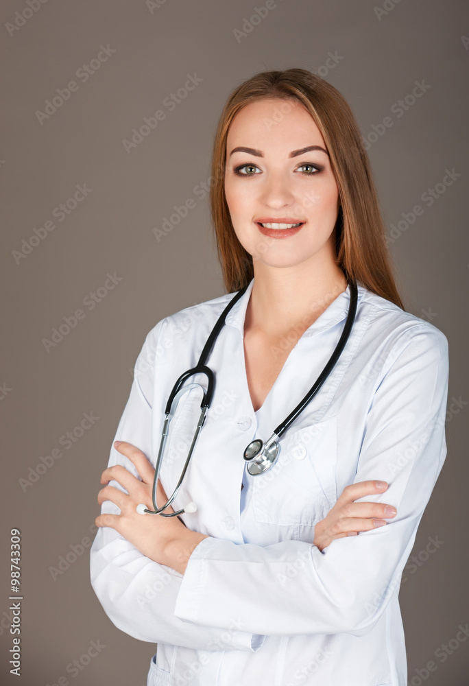 Smiling medical doctor woman with stethoscope. Isolated over gra Smiling medical doctor woman with stethoscope. Isolated over gra