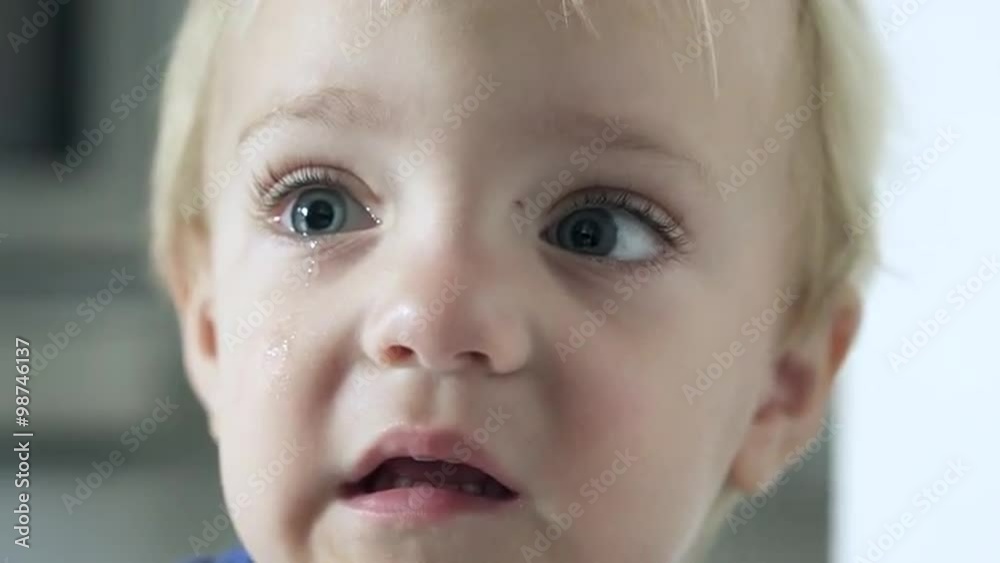A tearful little boy looks into the camera and weeps. A tearful little boy looks into the camera and weeps.