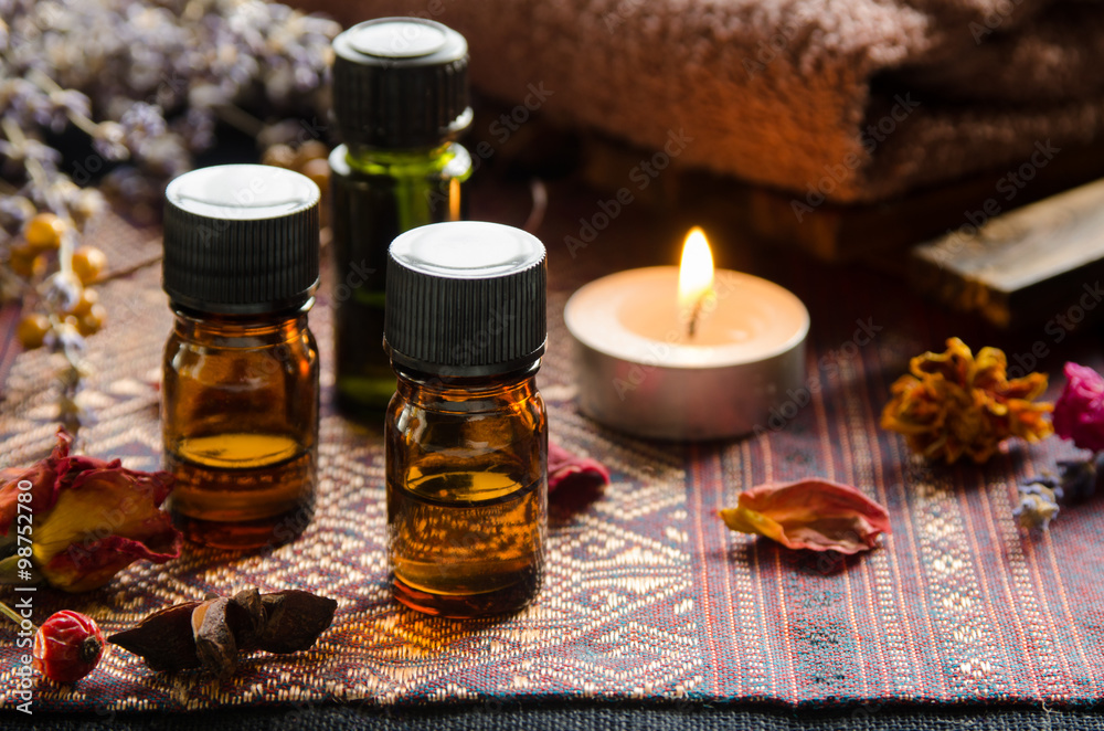 essential oils with candle and herbs