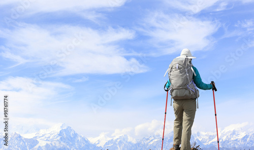 hiker on mountain peak looking at the beautiful snow mountain