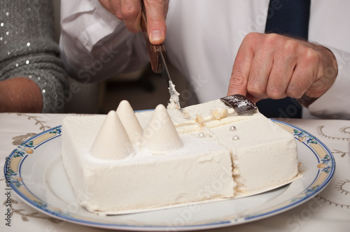 gros plan homme découpant un gâteau glacé de noël 