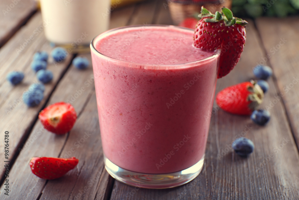 Glasses of fresh cold smoothie with fruit and berries, on wooden background Glasses of fresh cold smoothie with fruit and berries, on wooden background