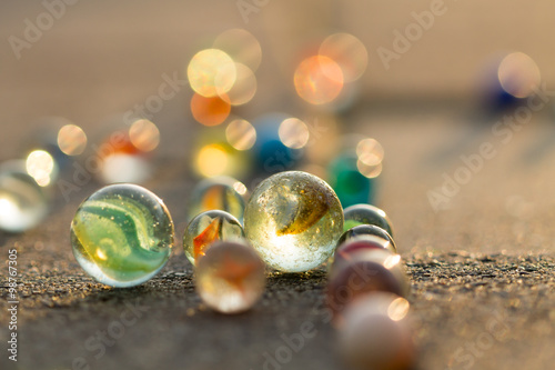 Marbles on the sidewalk in golden sunlight.
Diversity of colors. photo