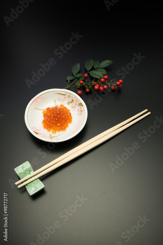 salmon roe with chopsticks. in Japan, salmon roe is recognized as one of the luxury food stuffs and served for the festive meals such as New Year dishes.