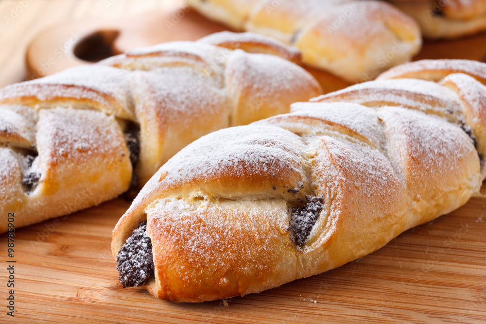 Homemade pastries with poppy seeds on a wooden background