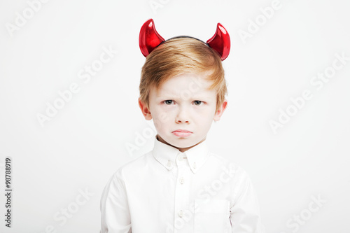 Little cute emotional boy with red horns on his head