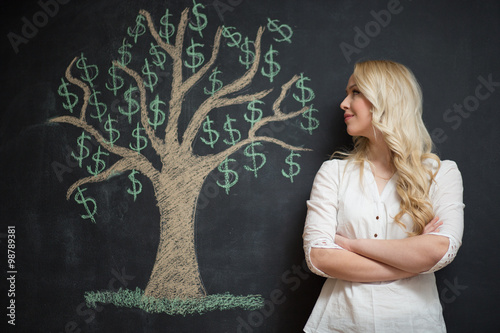 Happy blonde Business woman in front of chalk money tree drawing