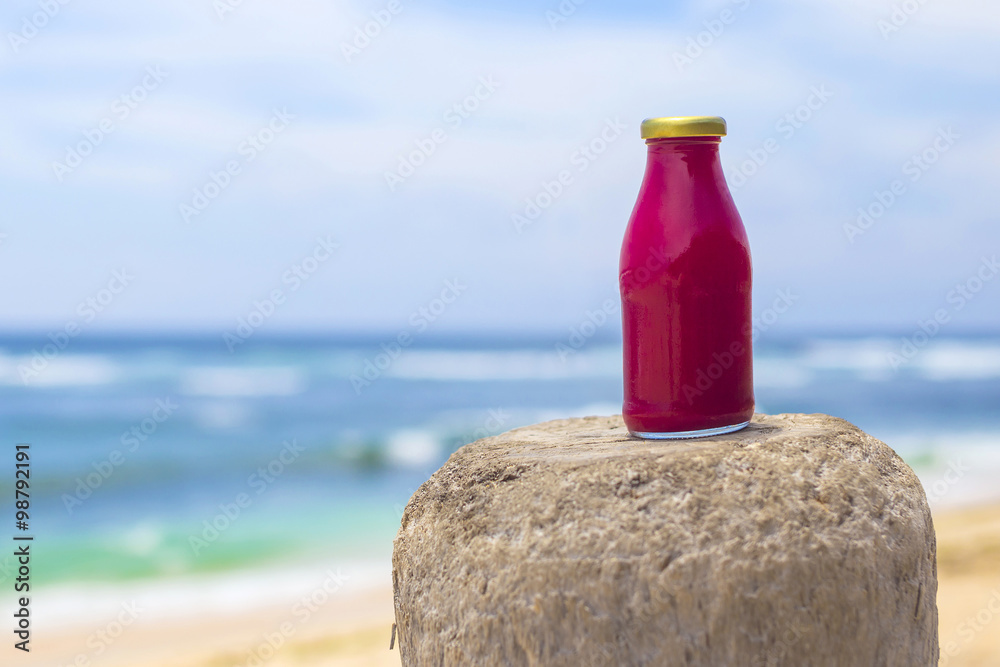 Healthy red smoothie with beach in background Healthy red smoothie with beach in background