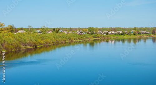 Spring landscape with the village on the bank of the river