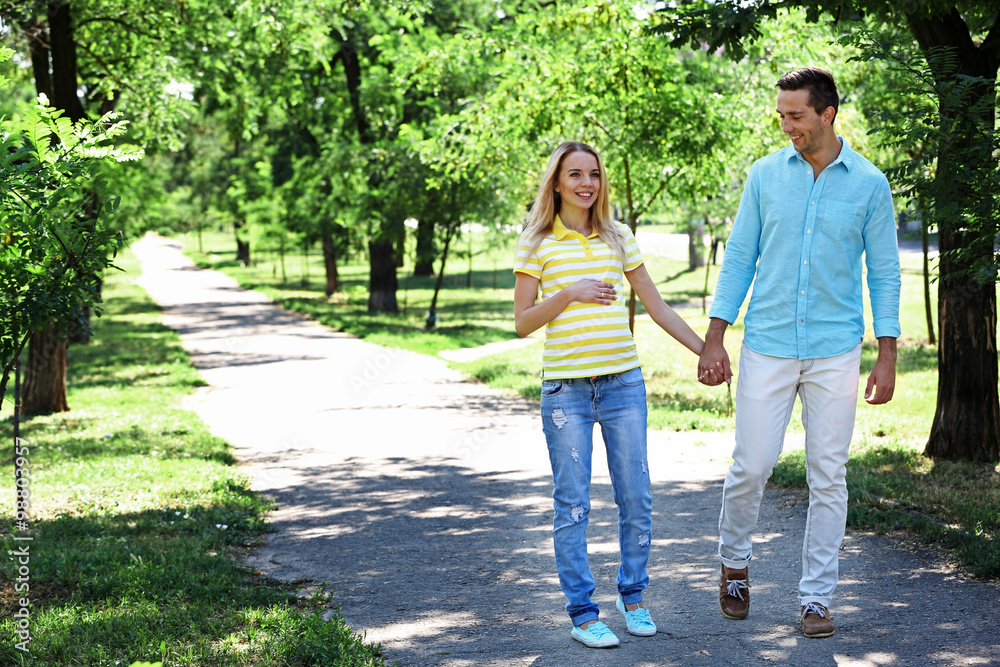 Young pregnant woman with husband walking in park Young pregnant woman with husband walking in park