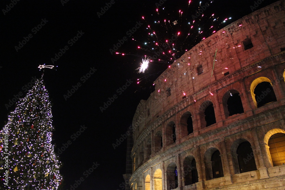 Obraz premium New year Eve in Rome, Fireworks at colosseum with a Christmas tree on its side