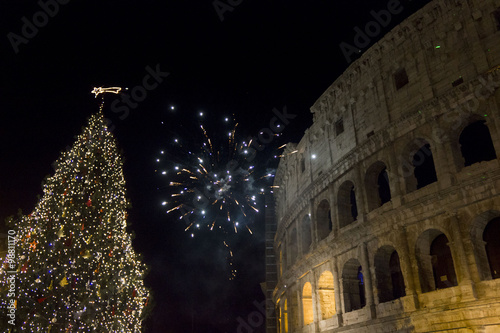 Canvas Print New year Eve in Rome, Fireworks at colosseum with a Christmas tree on its side