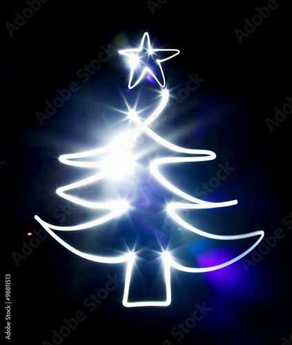 Christmas tree made with blue flashlight on a black