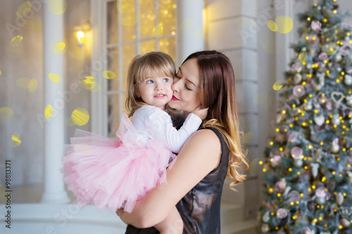 Mother with daughter on hands in the Christmas atmosphere