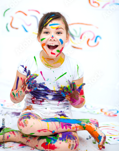 Cute girl playing with paints