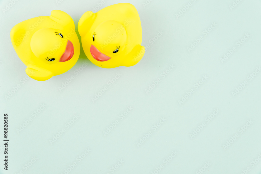 Pair of yellow rubber ducks isolated over colorful light blue background, love concept