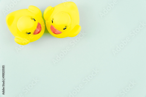 Obraz na płótnie Pair of yellow rubber ducks isolated over colorful light blue background, love concept w salonie