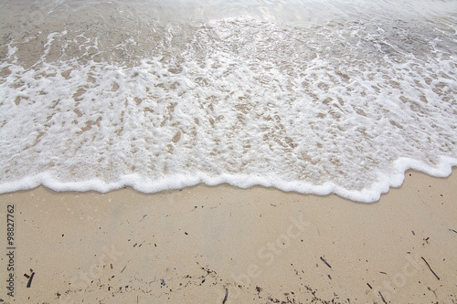 Foamy wave on sandy beach