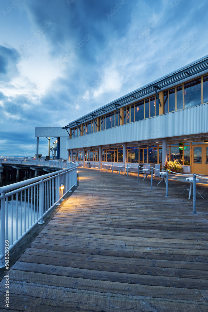 empty wooden footpath front of architecture at dusk